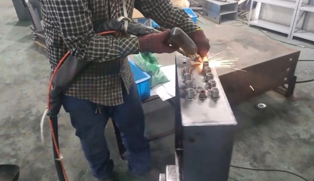 Worker grinding a fabricated metal housing
